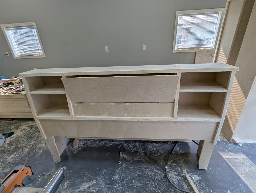 Custom bookcase-style headboard with built-in shelving, built in our workshop